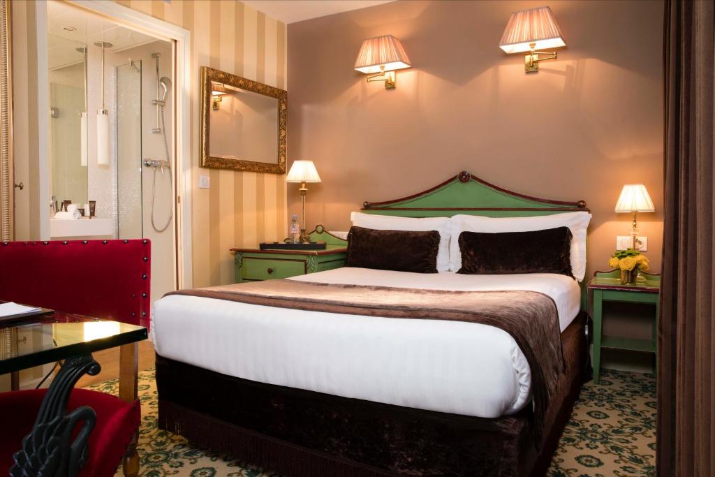a hotel room with a large bed and a mirror at Hotel Des Deux Continents in Paris