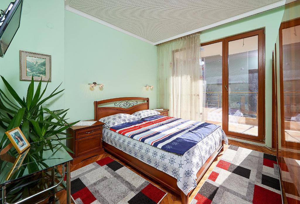 a bedroom with a bed and a table and a window at Apartment Dora in Pomorie