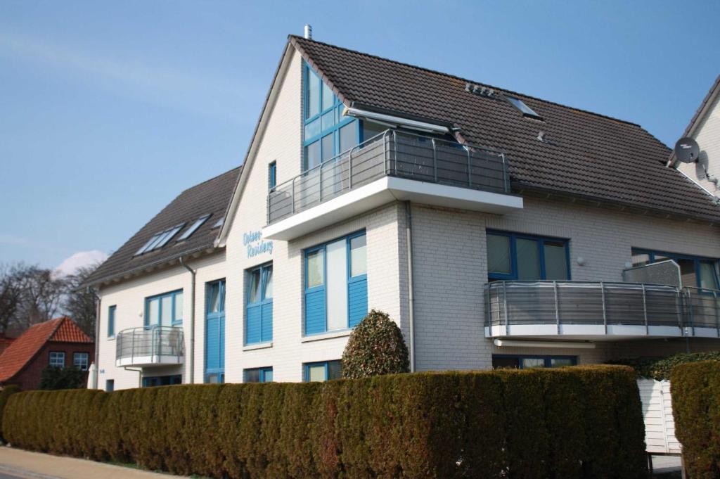 un bâtiment blanc avec un toit noir dans l'établissement Niehaus Ostseeresidenz App 4, à Pelzerhaken