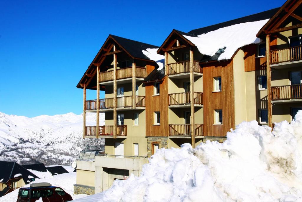 un hotel en la nieve con edificios cubiertos de nieve en Résidence Néméa Le Hameau de Balestas, en Germ