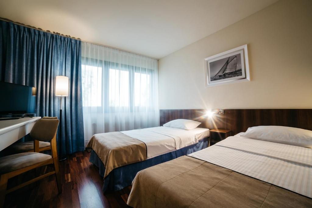 Postel nebo postele na pokoji v ubytování Omega Hotel