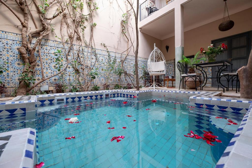 una gran piscina con azulejos azules y blancos en Riad Adrar, en Marrakech