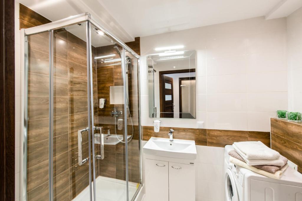 a bathroom with a shower and a sink at Alma Apartments Smolna in Warsaw