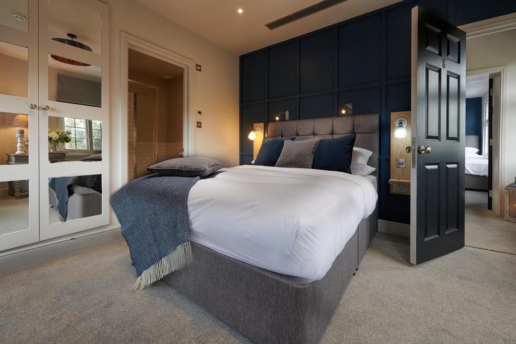 um quarto grande com uma cama grande e armários pretos em The Bridge Pub & Rooms em Londres