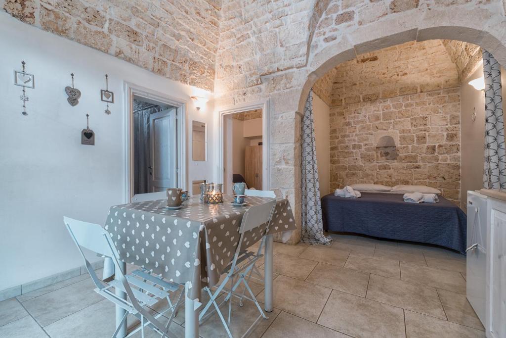 a dining room with a table and a bed in a room at White House Flats & Studios in Ostuni