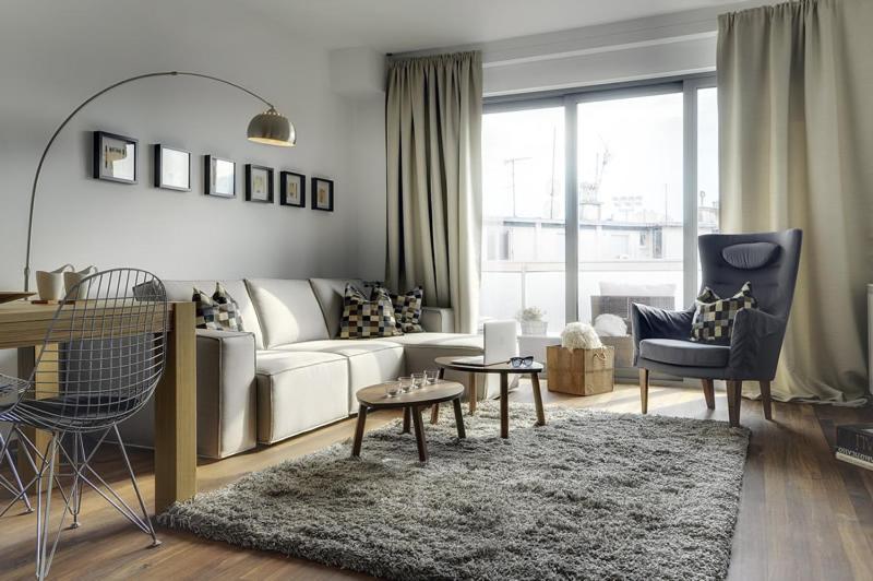 uma sala de estar com um sofá branco e um tapete em Apartment City Business em Pula