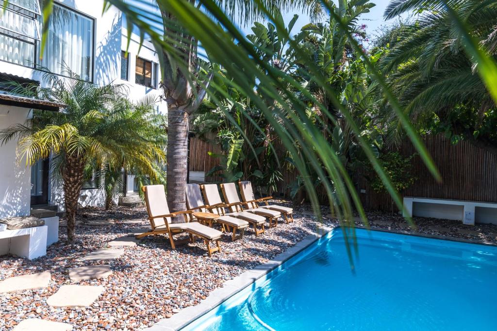 un grupo de sillas sentadas junto a una piscina en Antrim Villa Guesthouse, en Ciudad del Cabo