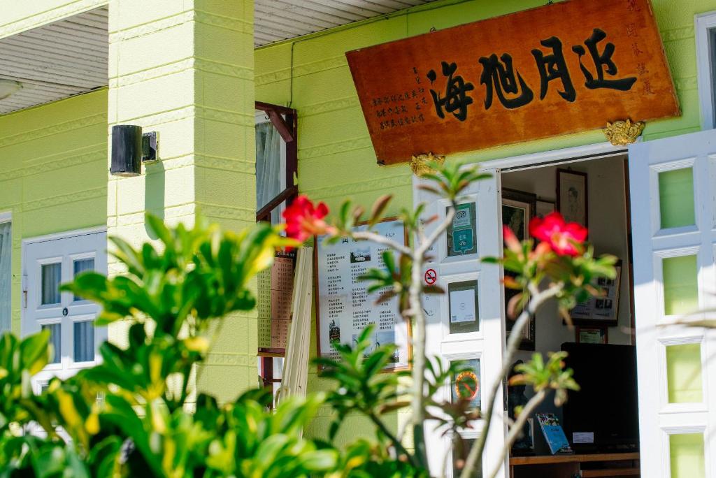 a yellow building with a sign on the door at Sea-Hi B&amp;B in Yanliau