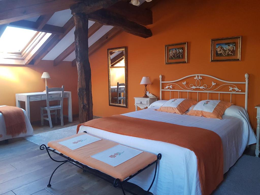 a bedroom with a large bed with orange walls at Posada La Rivera De Escalante in Escalante