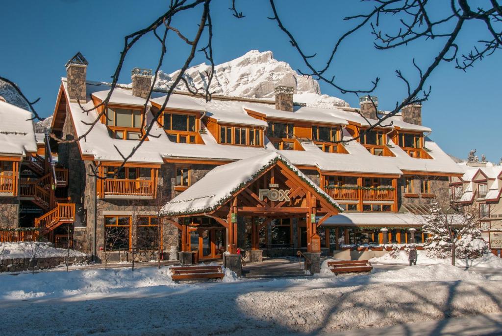 a large ski lodge with snow on the roof at Fox Hotel and Suites in Banff