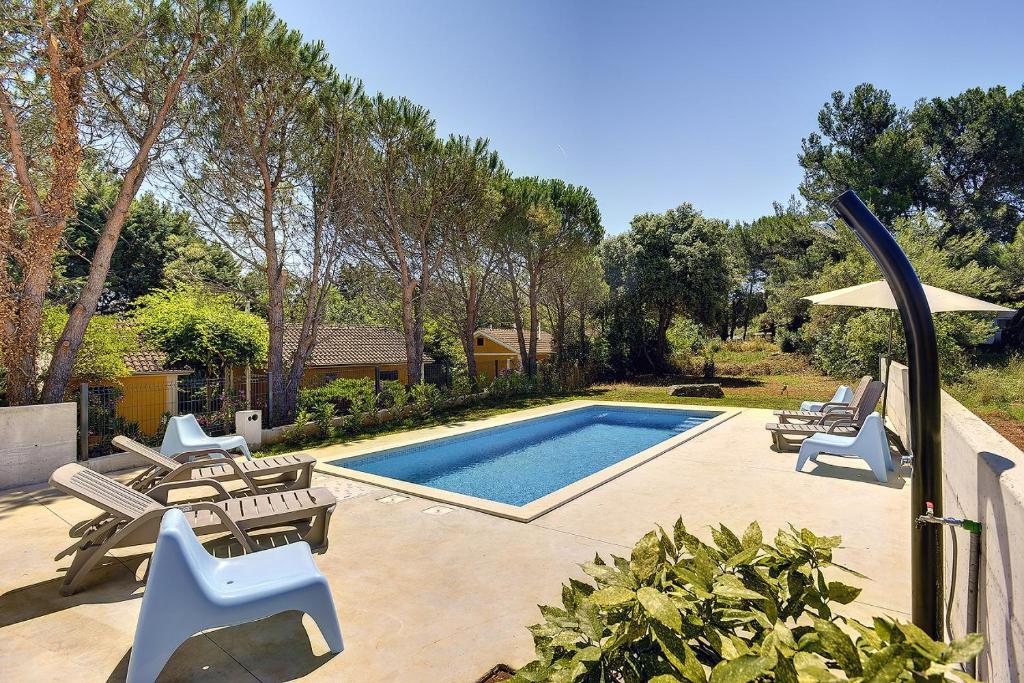 uma piscina com espreguiçadeiras e uma piscina em Villa Chiara em Premantura