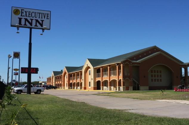 un gran edificio de ladrillo con un cartel delante en Executive Inn Brookshire, en Brookshire