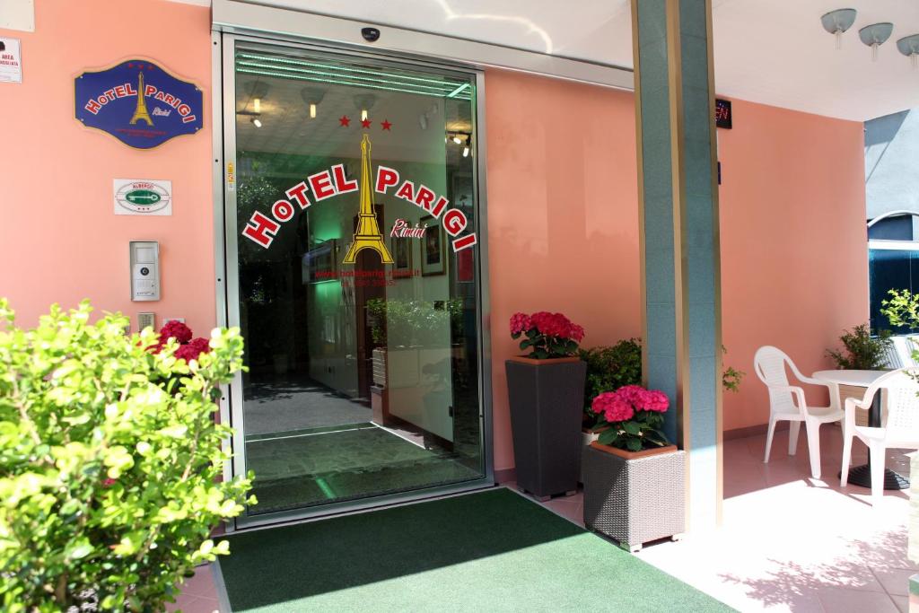een ingang van het restaurant met een hotelbord op de deur bij Hotel Parigi in Rimini