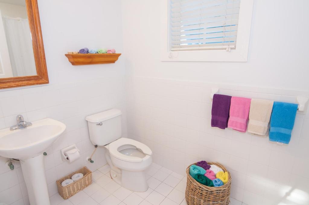 a white bathroom with a toilet and a sink at Casa 325 Guesthouse in Key West