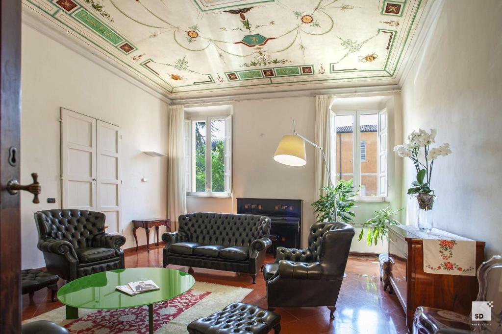 een woonkamer met stoelen en een tafel en een plafond bij Palazzo Galletti Abbiosi in Ravenna