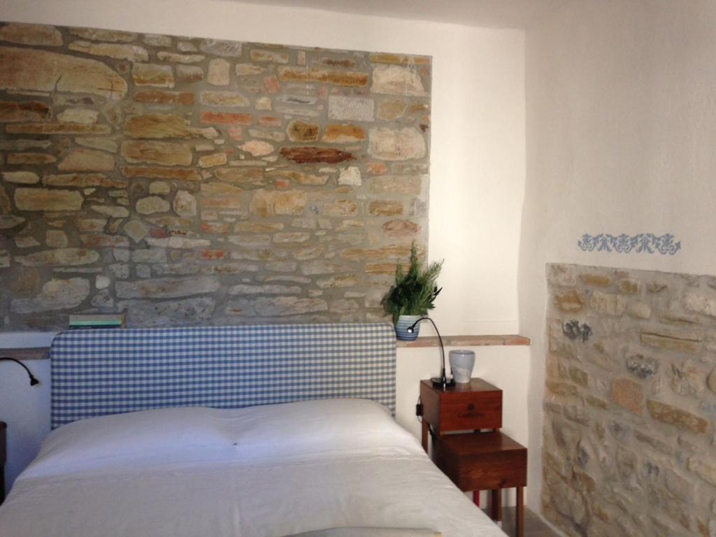 a bedroom with a stone wall and a bed at UvaMatta in Carmiano