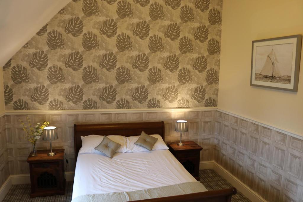 a bedroom with a bed with two night stands and two lamps at Victoria House in Barrow in Furness