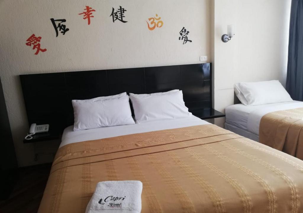 Postel nebo postele na pokoji v ubytování Hostal Capri