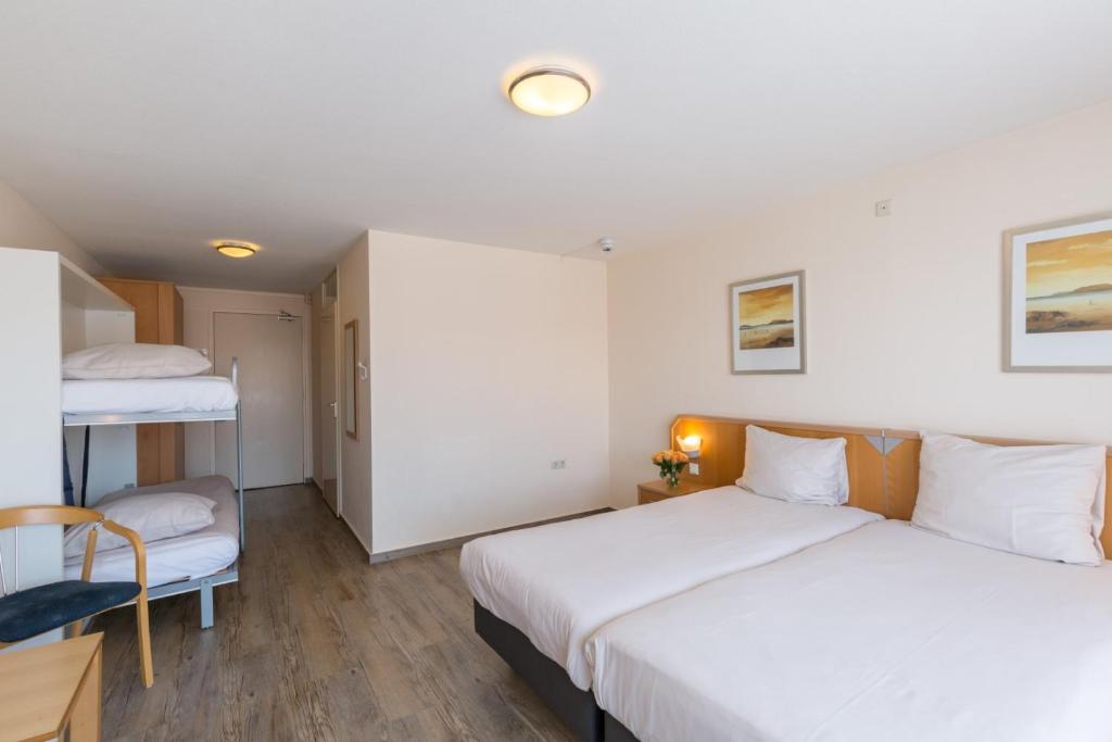 Postel nebo postele na pokoji v ubytování Strandhotel Bos en Duin