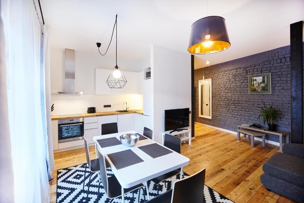 een keuken en een woonkamer met een witte tafel en stoelen bij Ex Factory apartment in Rīga