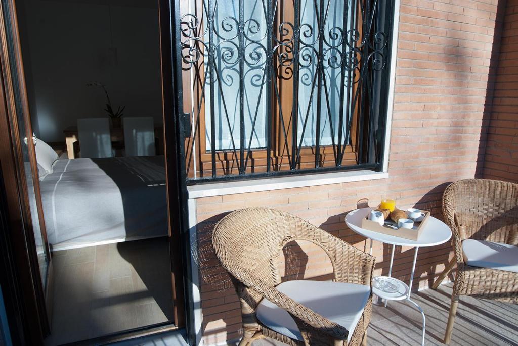 een balkon met een tafel en stoelen en een bed bij Il Giardino Delle Tartarughe in Rome