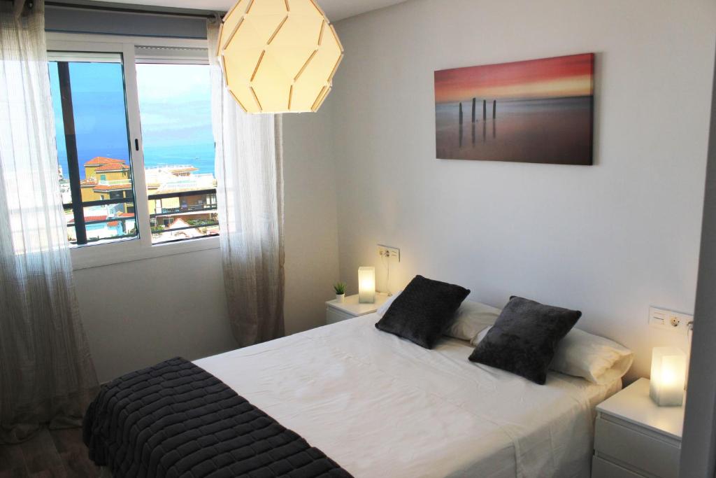 トレモリノスにあるNogalera Beach Apartmentのベッドルーム1室(ベッド1台、大きな窓付)