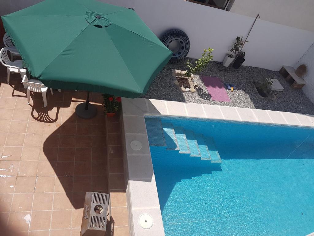 um guarda-sol verde ao lado de uma piscina em Casa Adriana em Murchas