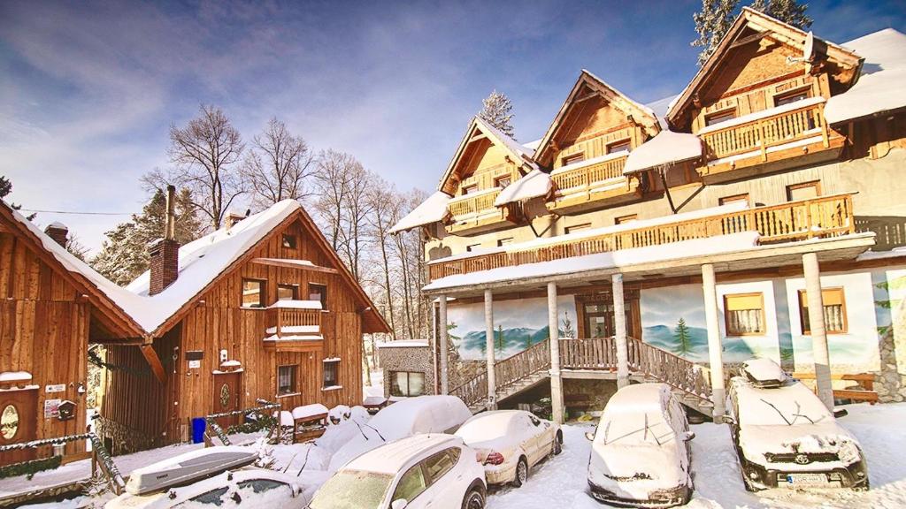 a large house with cars parked in the snow at Pod Smerkami in Szklarska Poręba