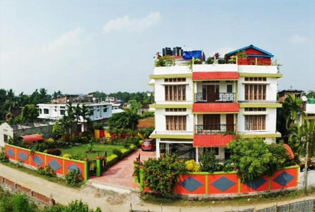 a large white building with plants in front of it at Eagle Nest Home Stay in Guwahati
