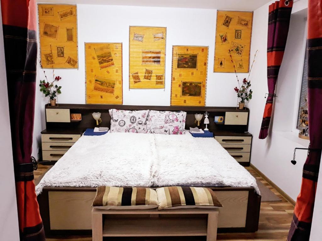 a bedroom with a bed and some pictures on the wall at Apartment Shesti Uchastak in Gabrovo