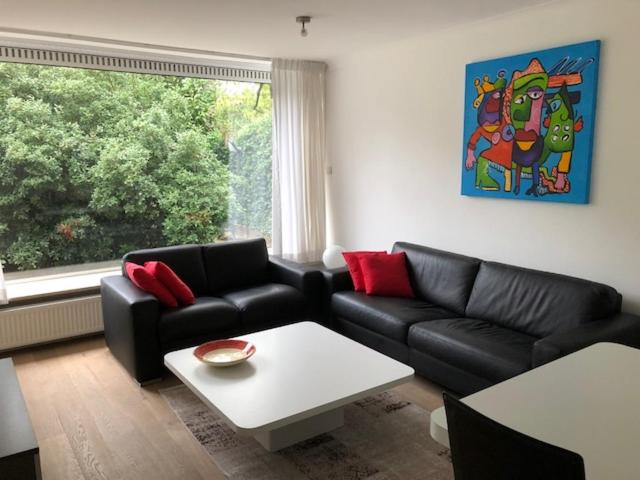 Sala de estar con 2 sofás y mesa en Appartement BBwB, en Breda