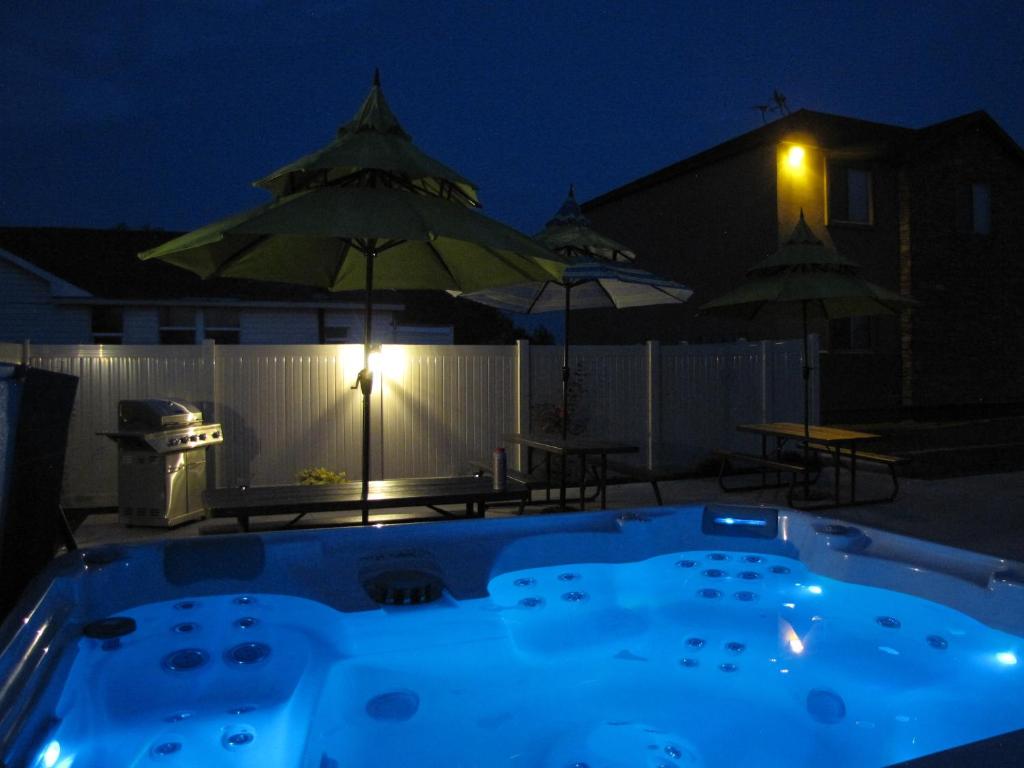 a swimming pool at night with a table and umbrellas at Cedar Canyon Condos in Blanding
