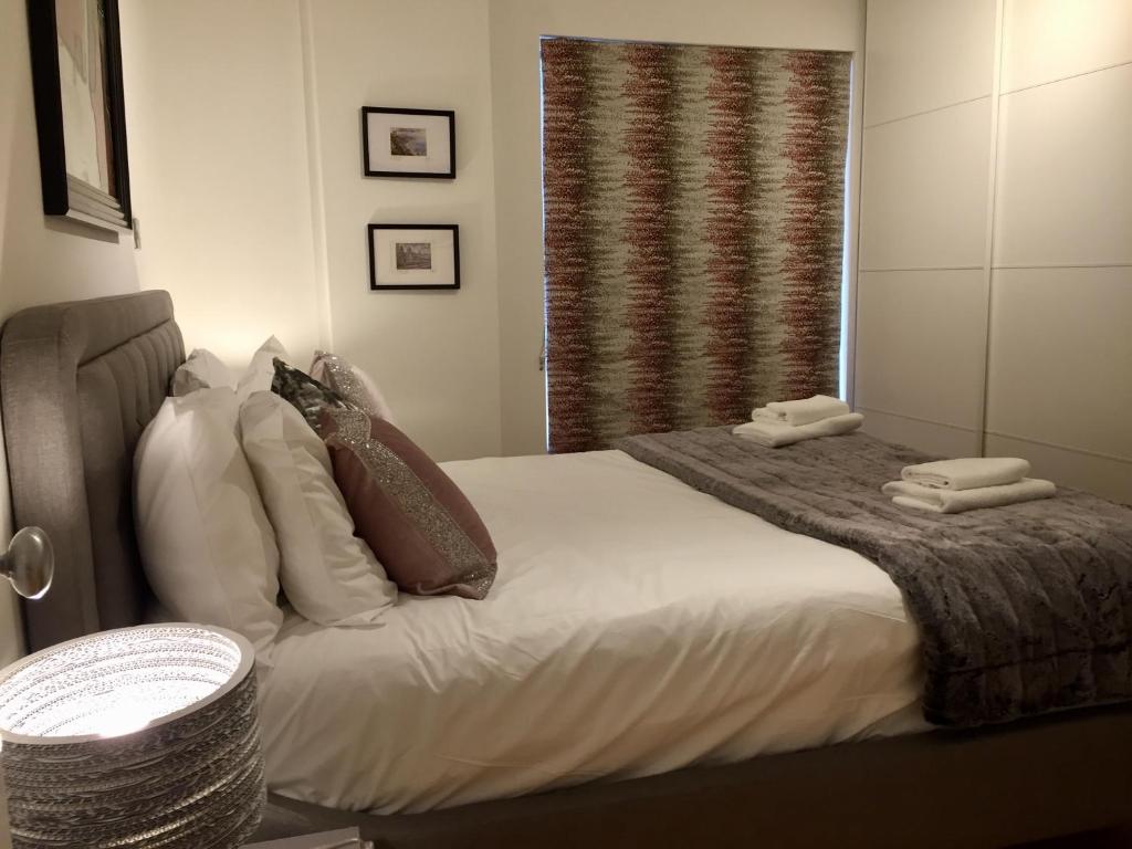 1 dormitorio con cama con almohadas y ventana en City Centre Belfast Free Parking en Belfast
