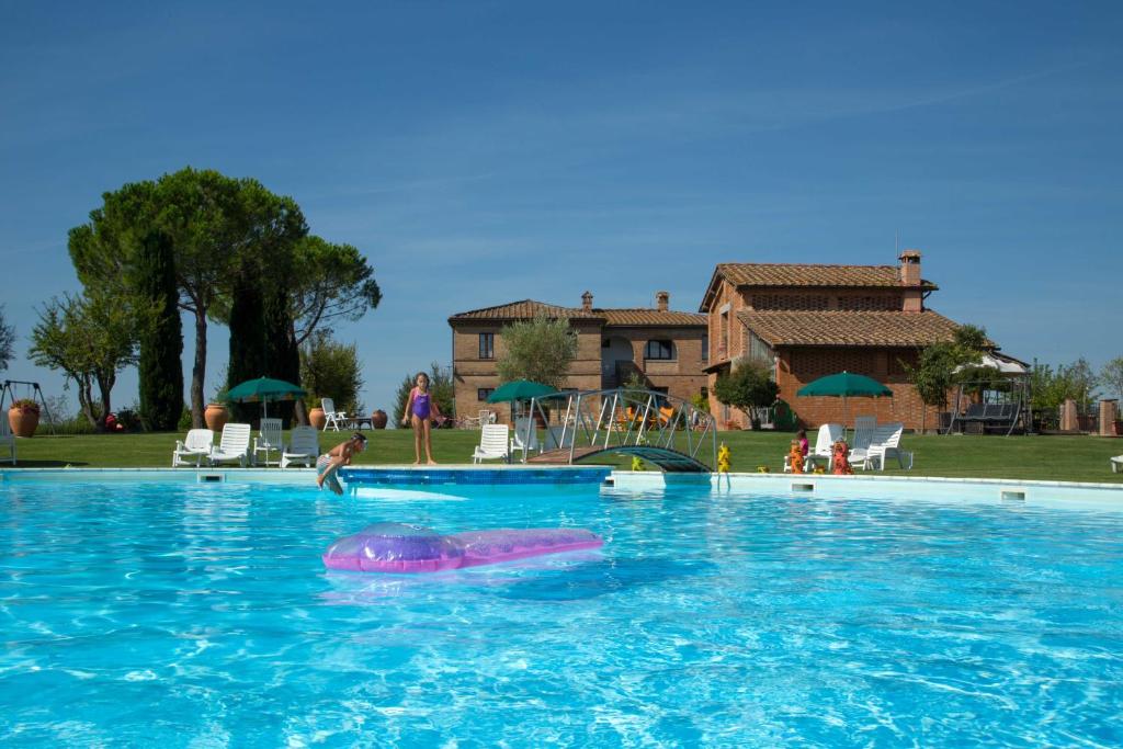 a person swimming in a large swimming pool at Casavacanze Vesta in Isola d'Arbia