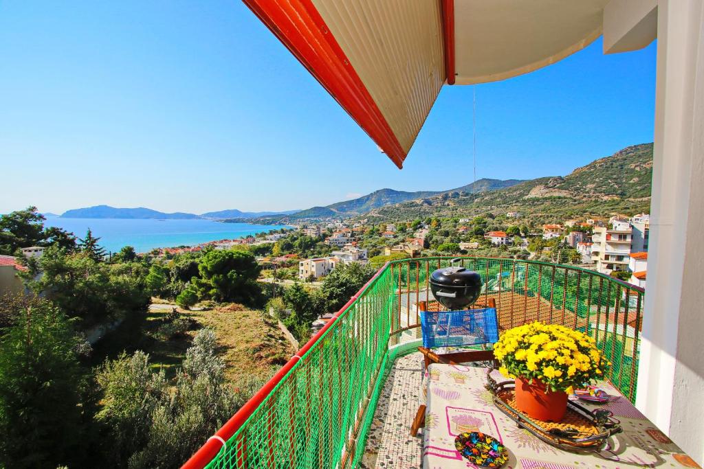 a balcony with flowers and a view of the water at Konstantina’s House in Paleo Tsifliki