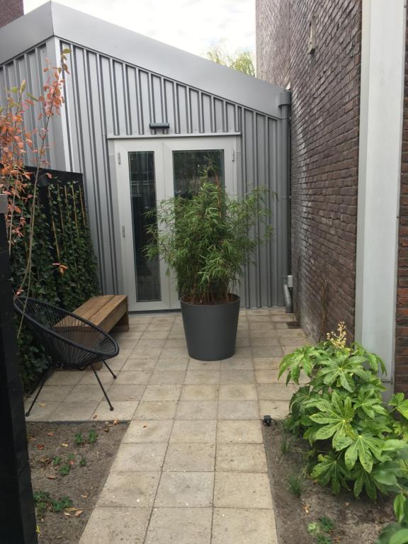 a patio with a plant in a pot next to a building at Terrace Apartment Cyclades in Amsterdam