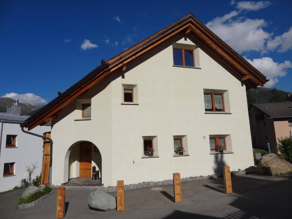 a white house with a brown roof at Crusch 32 in Samedan