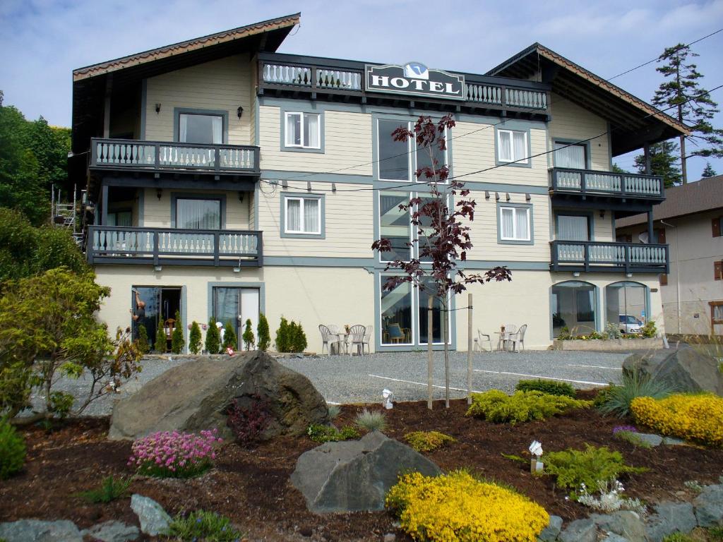 a hotel with a garden in front of it at Heron's Landing Hotel in Campbell River