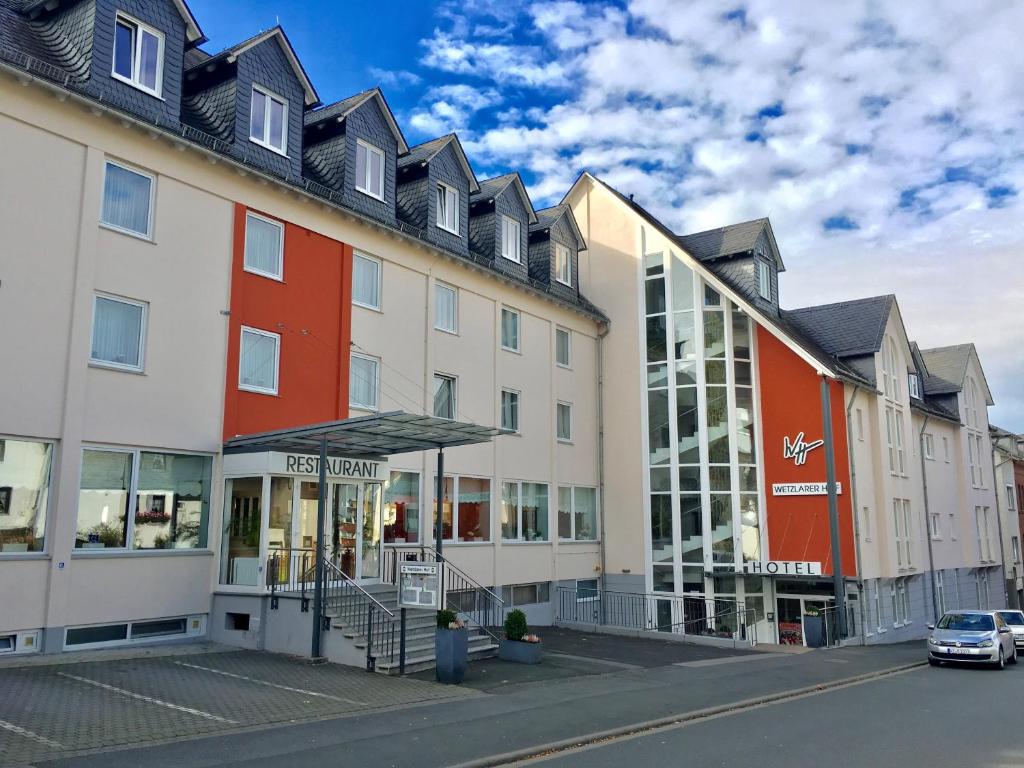 une rangée de bâtiments dans une rue avec une voiture dans l'établissement Hotel Wetzlarer Hof, à Wetzlar