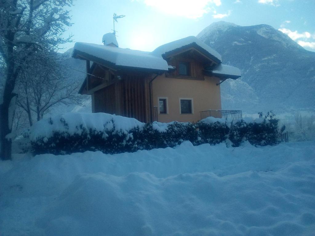 una casa con una croce sul tetto nella neve di Affittacamere Les Noyers a Verrayes