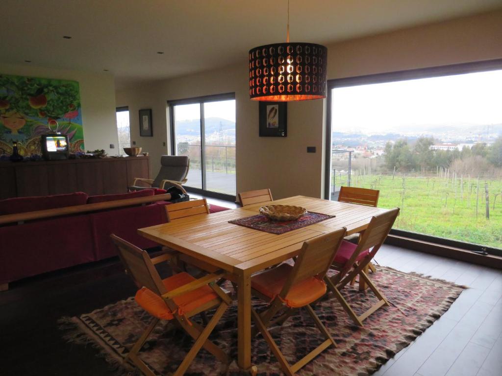 a dining room with a wooden table and chairs at Casa Nova in Guimarães