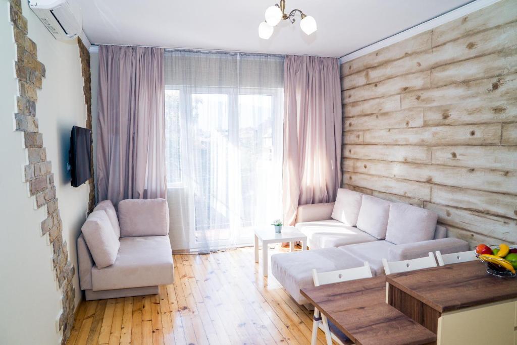 a living room with a white couch and a wooden wall at Sofia Central Luxury Apartment in Sofia