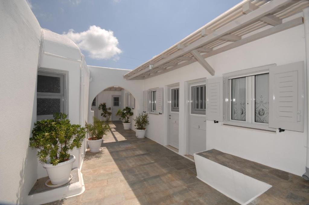 a courtyard with potted plants in a white building at Hotel Milena in Mýkonos City