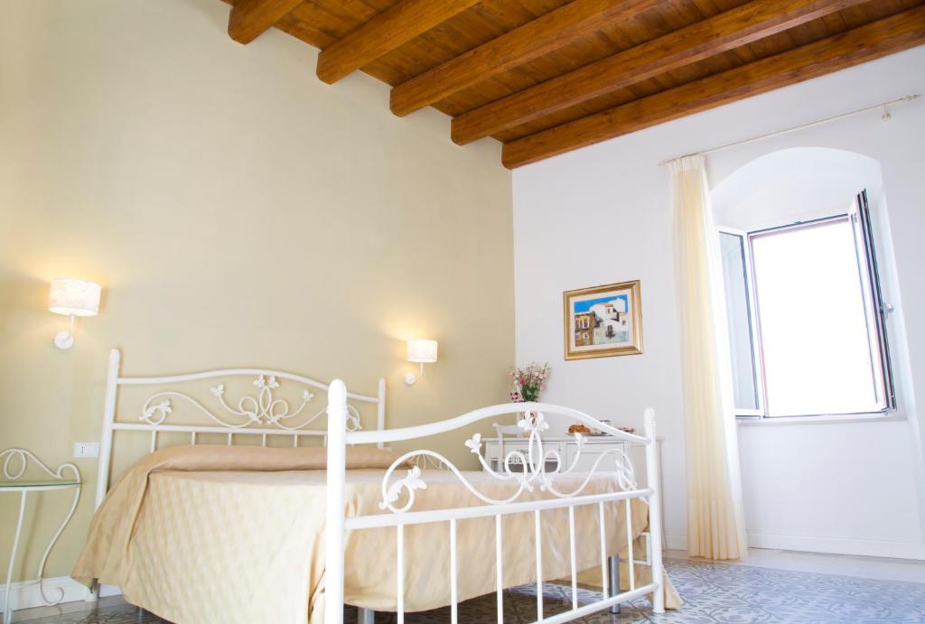 a bedroom with a white bed and a window at B&B Monsignore in Vieste