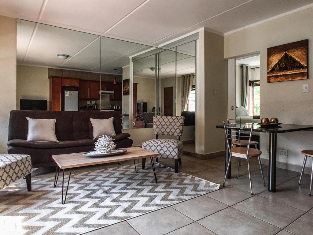 een woonkamer met een bank en een tafel bij Alimama Spaces: Chelsea Pad in Johannesburg