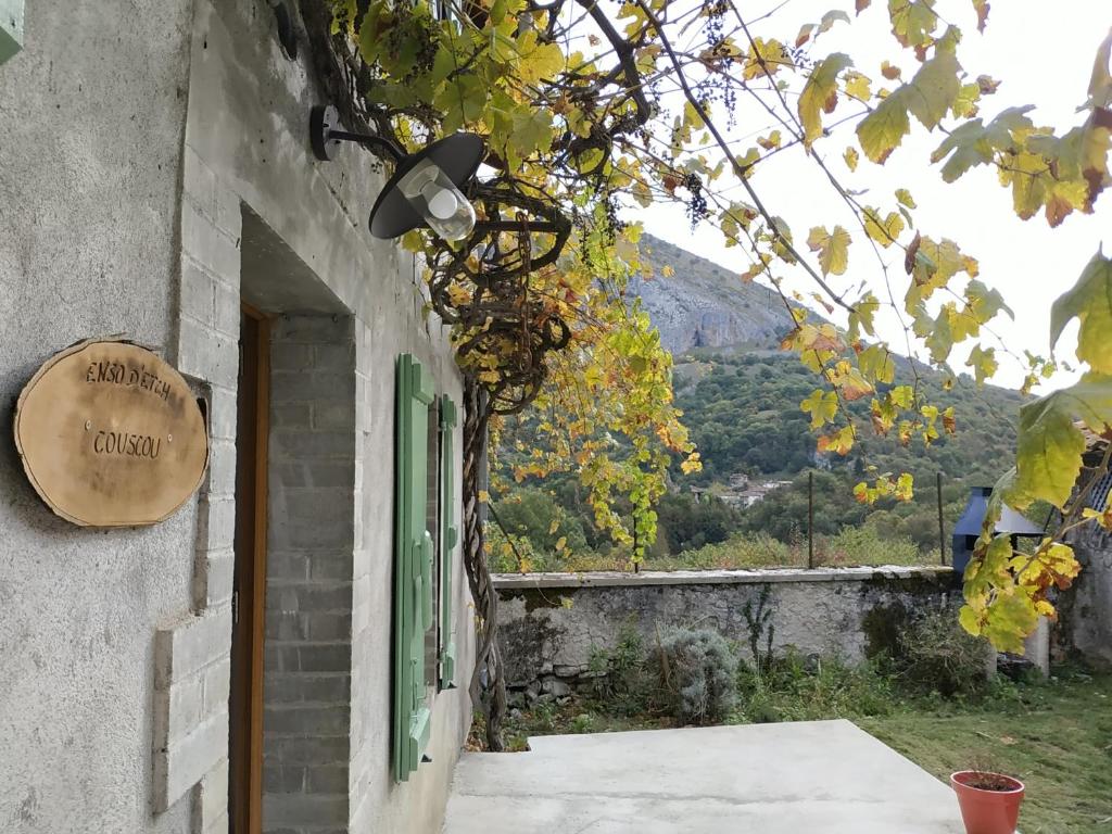 - un bâtiment avec une porte verte et une fenêtre dans l'établissement L'ostaou des hauts de Barousse, à Bramevaque