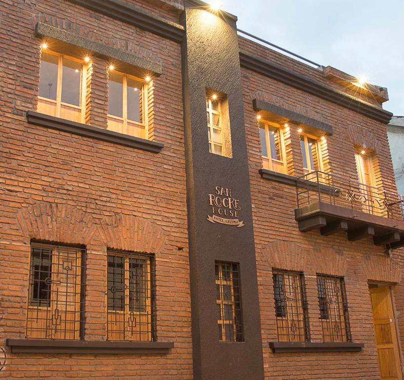 a brick building with windows and a sign on it at San Rocke House in Cuenca