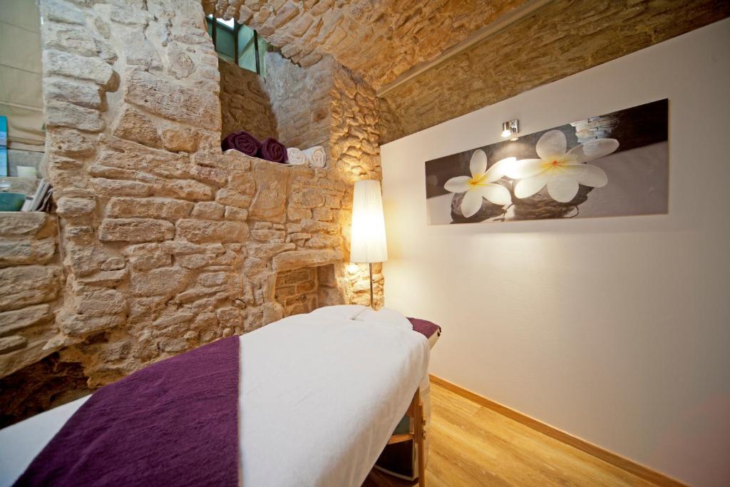 a bedroom with a stone wall and a bed at Hotel Le Place d'Armes - Relais & Châteaux in Luxembourg