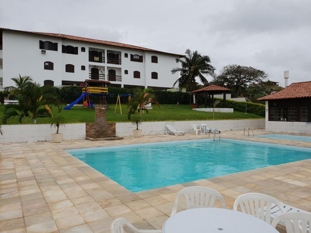 a swimming pool in front of a building at Cantinho do Village in São Pedro da Aldeia