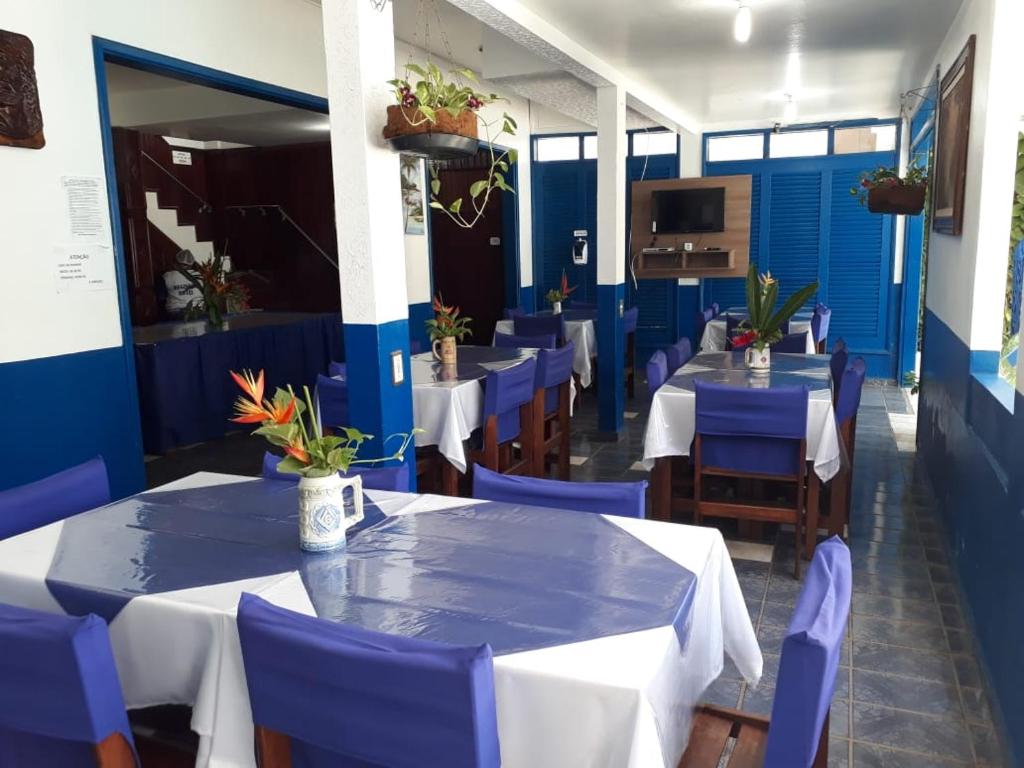 a restaurant with blue and white tables and chairs at Regine's Hotel in Itacoatiara